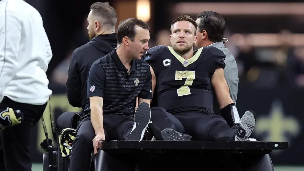 Taysom Hill #7 of the New Orleans Saints is carted off the field during the fourth quarter against the Los Angeles Rams at Caesars Superdome on December 01, 2024 in New Orleans, Louisiana.