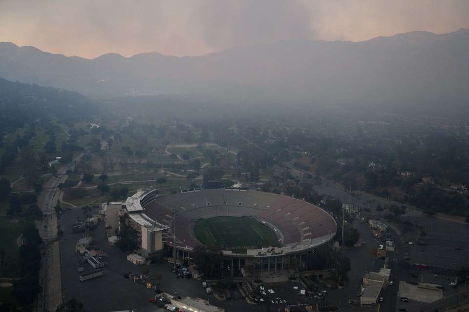 More than a week later and the Rose Bowl stadium now looks much different as an aerial image shows smoke in the distance of the venue from wildfires