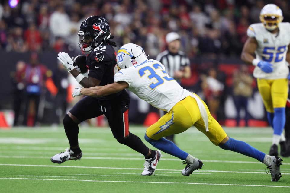 A football player making a reception while being tackled.