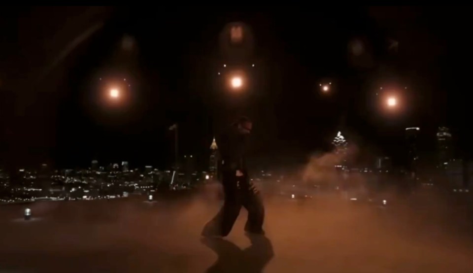 Screenshot of Scott performing his song "4x4" at night in front of a city skyline.