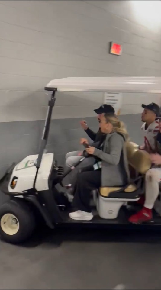 Three people riding in a golf cart.