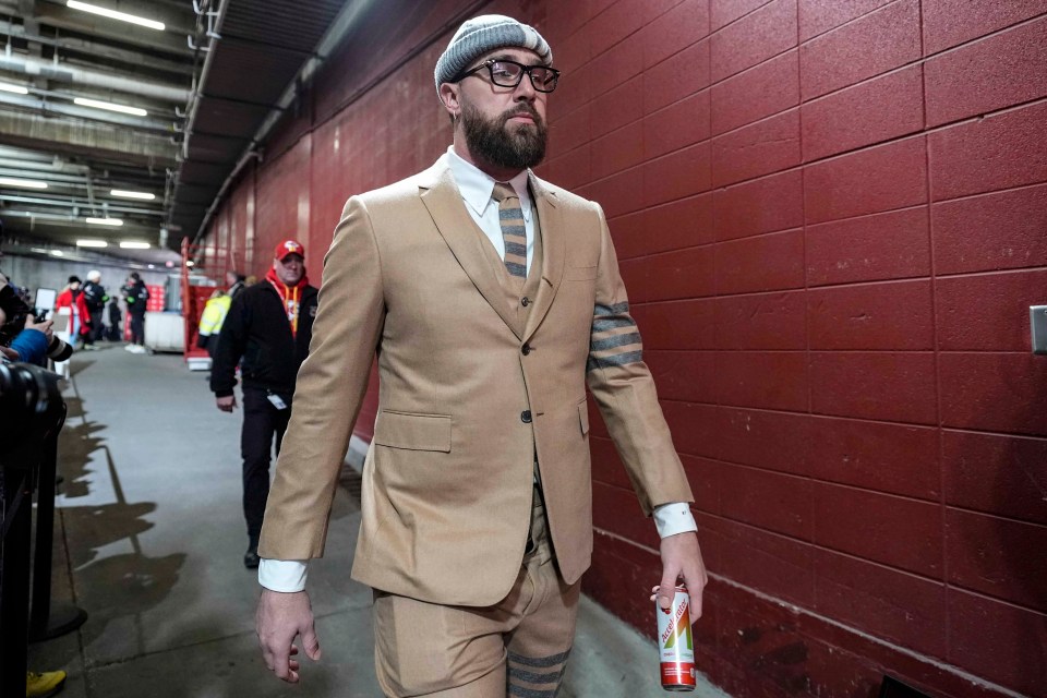 Travis Kelce in a tan suit arriving at Arrowhead Stadium.