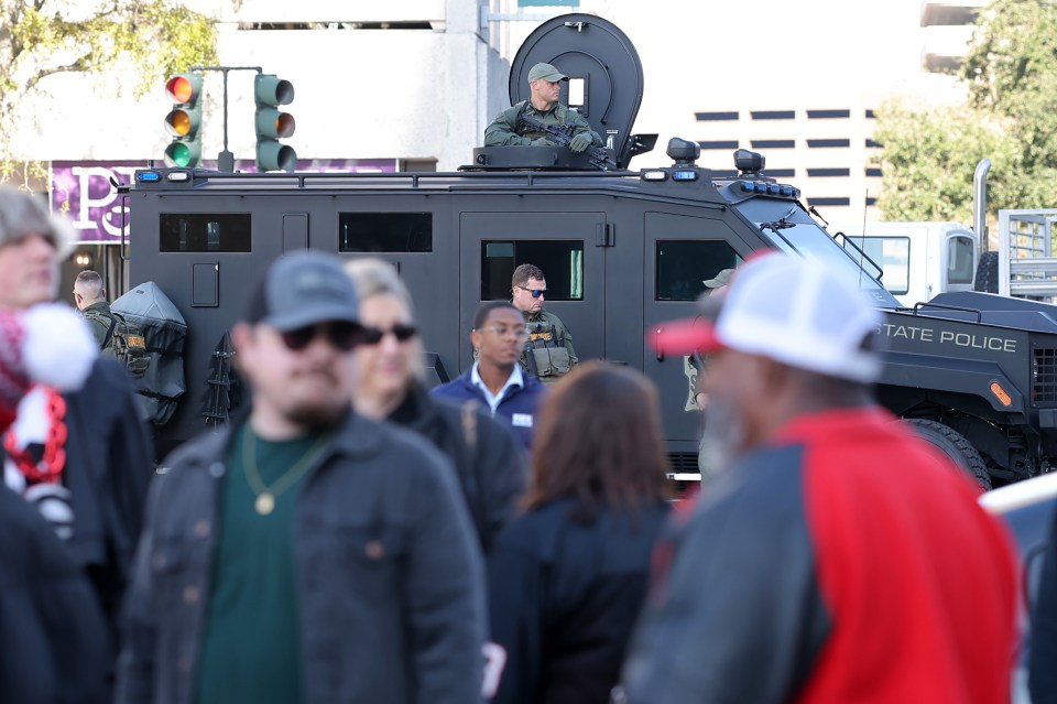 Law enforcement officers on an armored vehicle patrol.