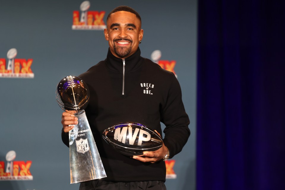 Jalen Hurts holding the Super Bowl LIX MVP trophy and Vince Lombardi Trophy.