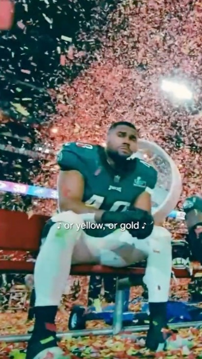 Football player sitting amidst confetti.