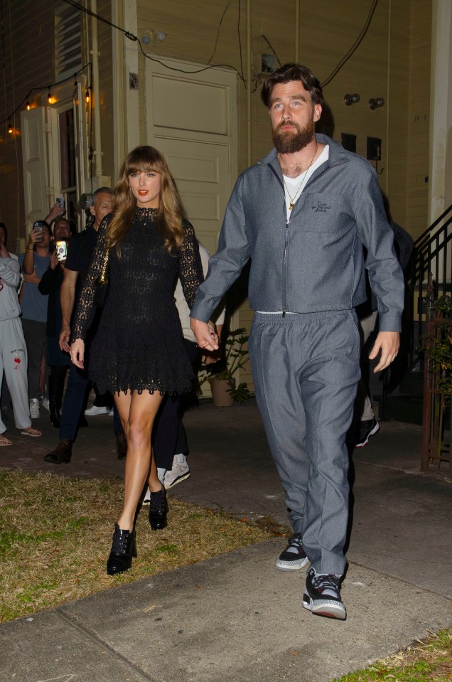 Taylor Swift and Travis Kelce holding hands leaving a restaurant.